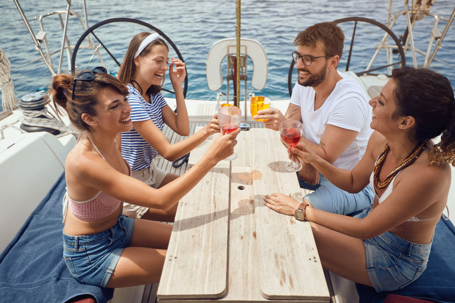 Couples cheering drinks on a boat, with water in the background