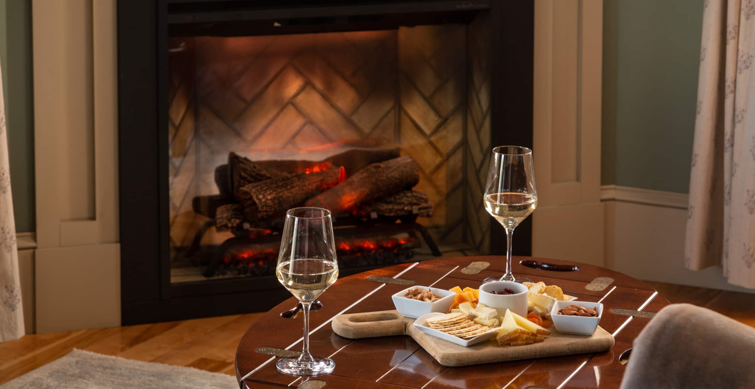 Romantic nights in with a cheese board and glasses of wine in front of the fireplace