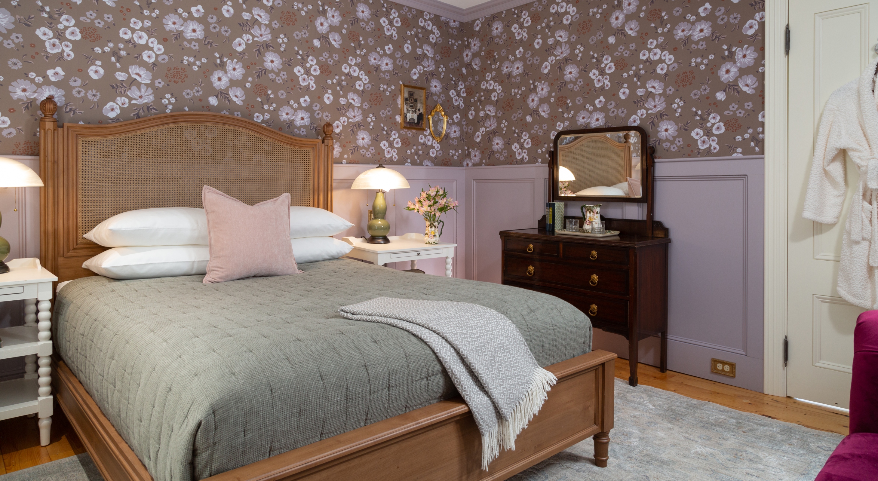 Queen bed in a room with a window and antique dresser with mirror at our Maine Coast B&B