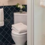 Unique corner toilet and pedestal sink in bath with blue tile
