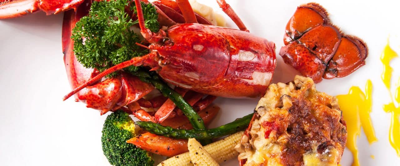 Plate of lobster, broccoli, and corn