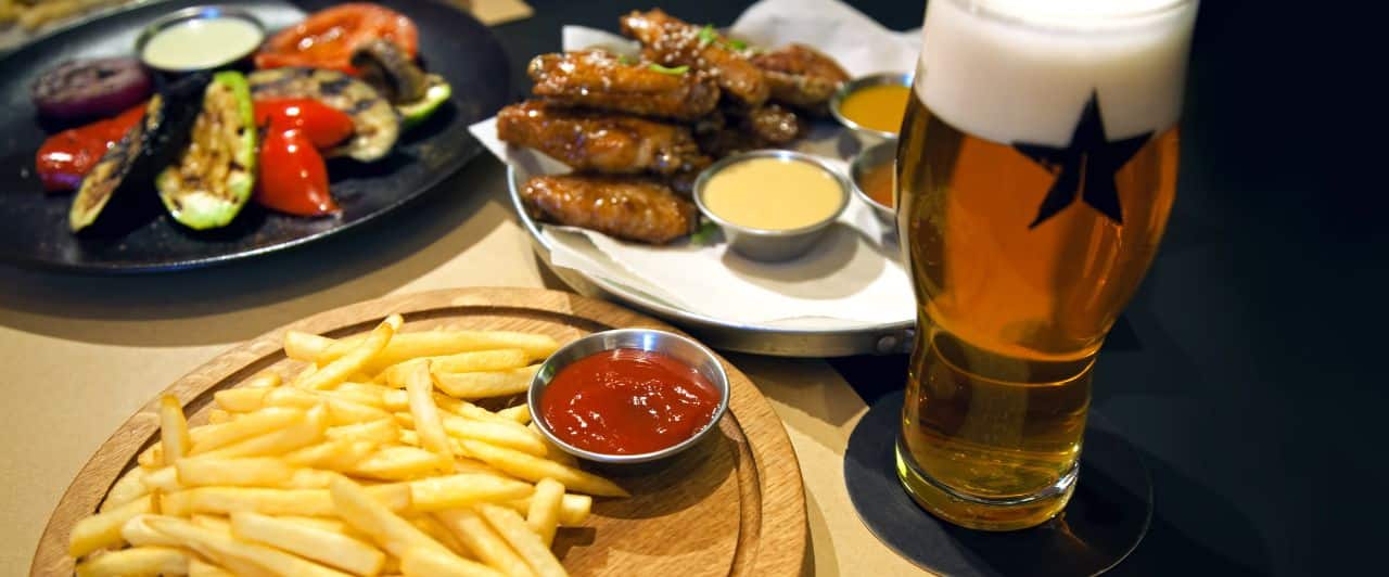 Dinner at a pub | fries, hot poppers, wings, and beer