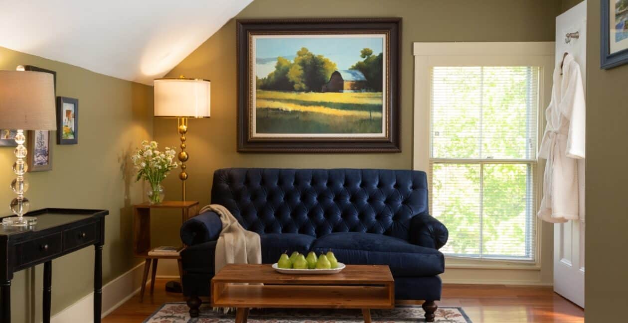 Sitting room with blue sofa, tables, and large painting