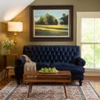 Sitting room in the Willard Room with a blue sofa and large painting.