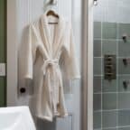 robe on door with handheld shower head and jets